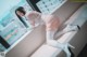 A woman in a nurse outfit is sitting on a couch.