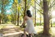 A woman riding a bike down a dirt road in a park.