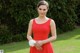 A woman in a red dress holding a white flower.