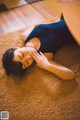 A woman laying on the floor with her eyes closed.