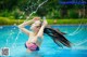 A woman in a red, white and blue bikini splashing water on her hair.