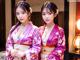 Two young women in kimonos standing next to each other.