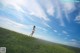 A woman standing on top of a lush green field.