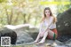 A woman sitting on a rock in the water.