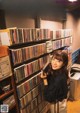 A woman standing in front of a wall of cds.