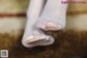 A close up of a woman's feet in white stockings.