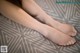 A close up of a woman's bare feet on a bed.